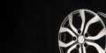 New alloy wheel of the car, close-up on a black background, wheel spokes. beautiful design. copy space. long layout Royalty Free Stock Photo