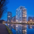 New apartment buildings reflected in canal at twilight, Turnhout, Belgium.