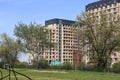 New area of ??residential high-rise buildings behind a thicket of trees, illuminated by sunlight on a spring day