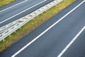 New asphalt road with with lines on both sides going to the right. Two drive lanes with guardrail in the middle. Travel road trip Royalty Free Stock Photo