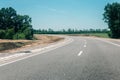 New asphalt road with roadside construction site in the forest. Countryside asphalt road reconstruction