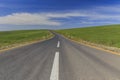 New asphalt road among the spring fields Royalty Free Stock Photo