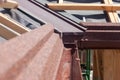 New asphalt shingle roof with brown rain gutter, wooden beams and vapour control layer. Royalty Free Stock Photo