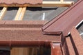 New asphalt shingle roof with brown rain gutter, wooden beams and vapour control layer. Royalty Free Stock Photo