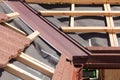 New asphalt shingle roof with brown rain gutter, wooden beams and vapour control layer. Royalty Free Stock Photo