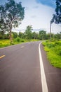 New asphalt winding curve road in the countryside with perspective white line and cloudy blue sky background. Royalty Free Stock Photo