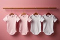 new baby bodysuits on light pink background. Pastel color. Empty place for text or logo on apparel
