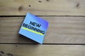 New Beginning text on sticky notes with wooden background