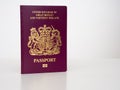 New Bergundy UK passport, no longer showing words `European Union`. With currency, pounds sterling. On white.