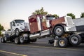 New big rigs semi trucks Trucks are transported in hitch one on top of the other forming a road train Royalty Free Stock Photo