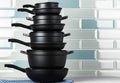 New black cookware against blue tile wall Royalty Free Stock Photo