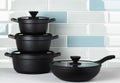 New black cookware against blue tile wall Royalty Free Stock Photo