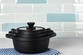 New black cookware against blue tile wall Royalty Free Stock Photo