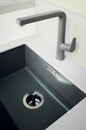 A new black kitchen sink made of artificial stone and a faucet. The concept of modern kitchen interior. Vertical photography Royalty Free Stock Photo