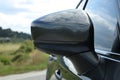 New black modern car outdoors, closeup of side rear view mirror Royalty Free Stock Photo