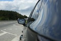 New black modern car outdoors, closeup of side rear view mirror Royalty Free Stock Photo