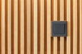 New black switch on the wall made of wood panels.