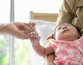 New born adorable girl sleeping on mother arm and holding her father finger on bed at home Royalty Free Stock Photo