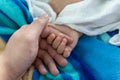 New born baby hand holding father hand during baby sleeping. newborn baby and dad hands. father taking care of her son kid happy Royalty Free Stock Photo