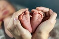 New born baby`s feet in mother hands - hearth shape