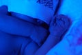 New born baby under the ultraviolet lamp. Royalty Free Stock Photo