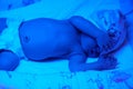 New born baby under the ultraviolet lamp. Royalty Free Stock Photo