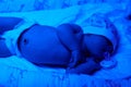 New born baby under the ultraviolet lamp. Royalty Free Stock Photo