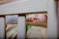 New born child in wooden co-sleeper crib. Infant sleeping in bedside bassinet. Safe co-sleeping in a bed side cot. Little boy taki