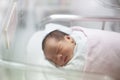 New born infant asleep in the blanket in delivery room