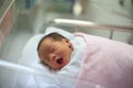 New born infant asleep in the blanket in delivery room