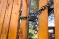 New bright orange wooden fence with thick steel chain and padlock Royalty Free Stock Photo