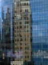 New building with blue windows that have a reflection of an old