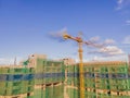 New buildings being constructed. Industrial building site. Shot of lifting crane and skyscraper under construction Royalty Free Stock Photo