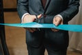 New business enterprise, opening, cutting a blue ribbon with scissors close-up Royalty Free Stock Photo