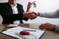 New car buyers and car salesmen are shaking hands to make agreements about car sales