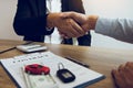 New car buyers and car salesmen are shaking hands to make agreements about car sales