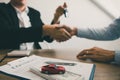 New car buyers and car salesmen are shaking hands to make agreements about car sales