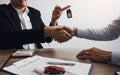 New car buyers and car salesmen are shaking hands to make agreements about car sales