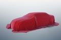 New car covered with red cloth. 3D rendered illustration Royalty Free Stock Photo