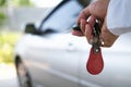 The new car owner uses the car key to unlock the door. Buy, sell, rent a car