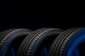 New car tires. Group of road wheels on dark background. Summer Tires with asymmetric tread design Royalty Free Stock Photo