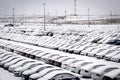 New cars covered with snow and parked in a distribution center on a cloudy day in the winter, a car factory