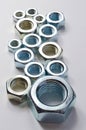 New chrome screw-nut of different sizes on a white background. Concept Royalty Free Stock Photo