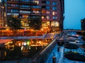 new city residential buildings and restaurants on water in dock and moored watercrafts near Royalty Free Stock Photo