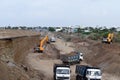A new city road is being constructed by lifting the soil from the excavator pile and filling it in the dumper truck at the