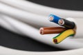 New colorful electrical wire on blurred background, closeup. Space for text Royalty Free Stock Photo