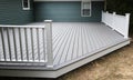 New composite deck on the back of a house with green vinyl siding