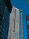 A new construction of a high-rise building with an unfinished facade and a crane on the side Royalty Free Stock Photo
