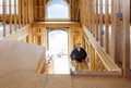 New construction house builder in hard hat walking on holding tablet PC