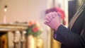 New coronavirus, closeup of woman's hands praying in church, copy space